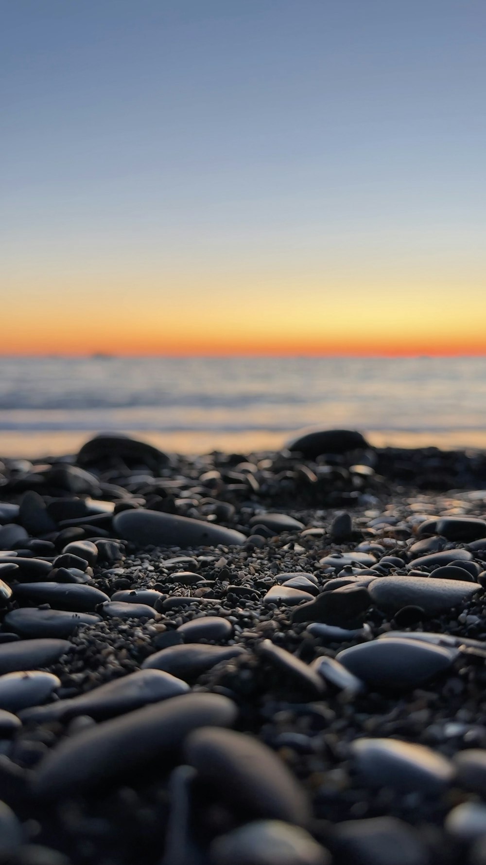 a close up of rocks on a beach near the ocean