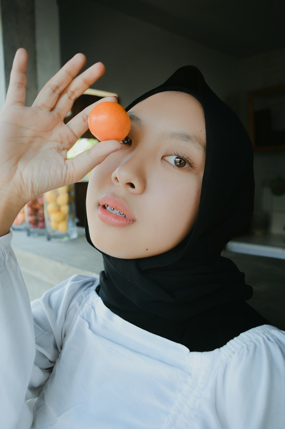a woman in a hijab holding an orange
