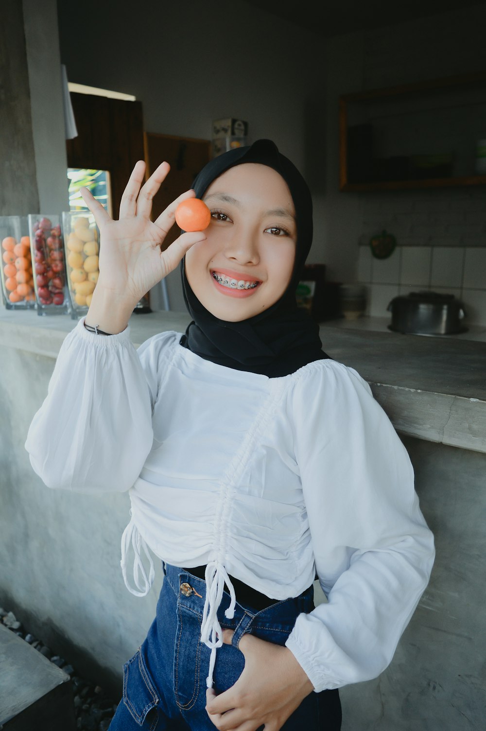 Une femme portant un hijab tient une orange