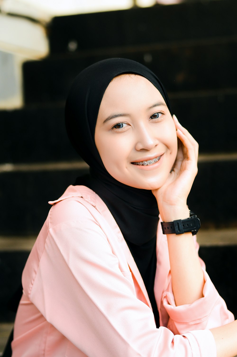 a woman in a hijab sitting on a set of stairs