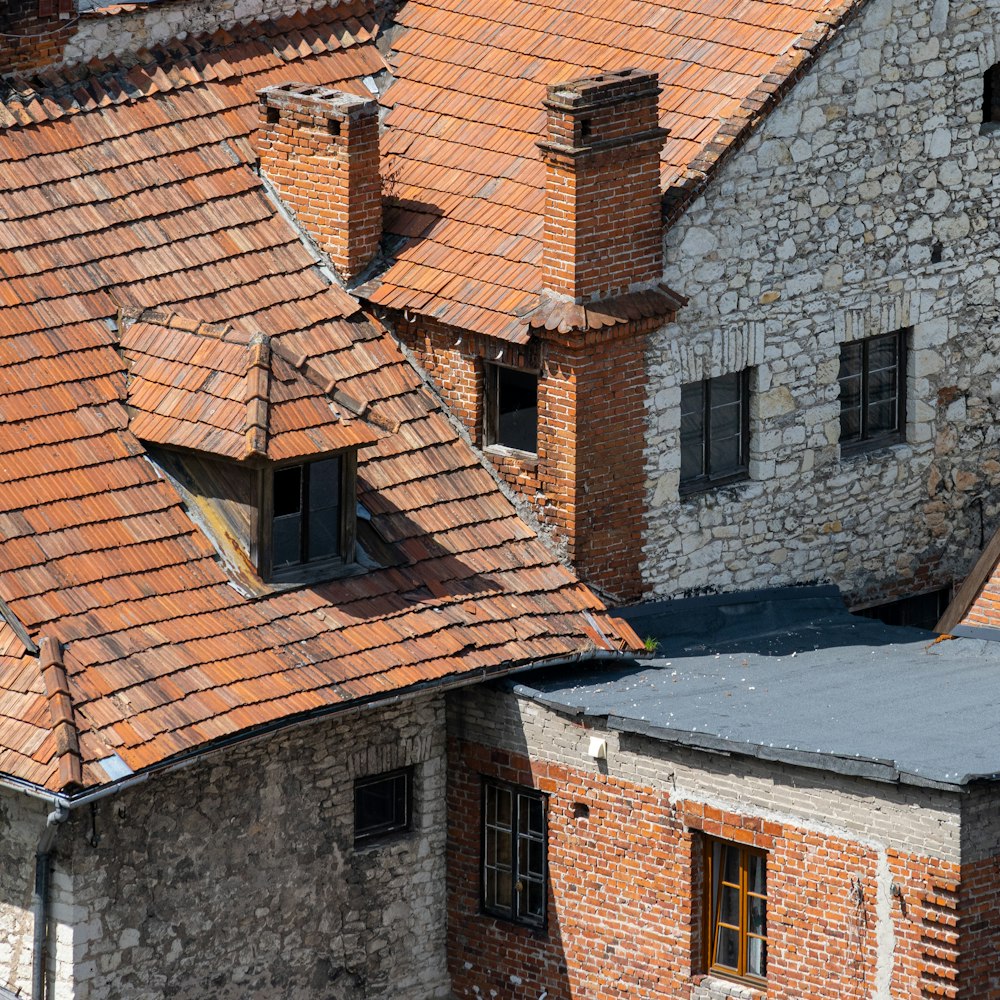 un vieux bâtiment en brique avec un toit de tuiles rouges