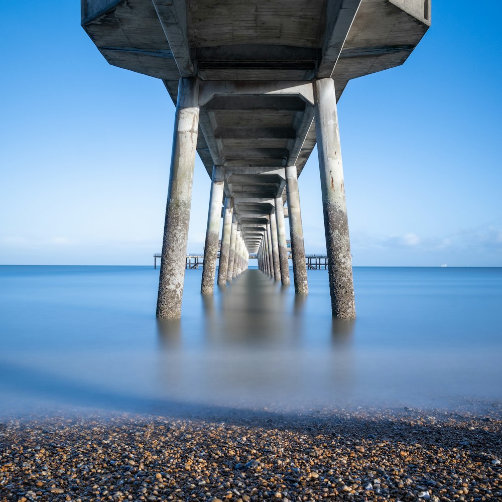 a long pier stretches out into the ocean