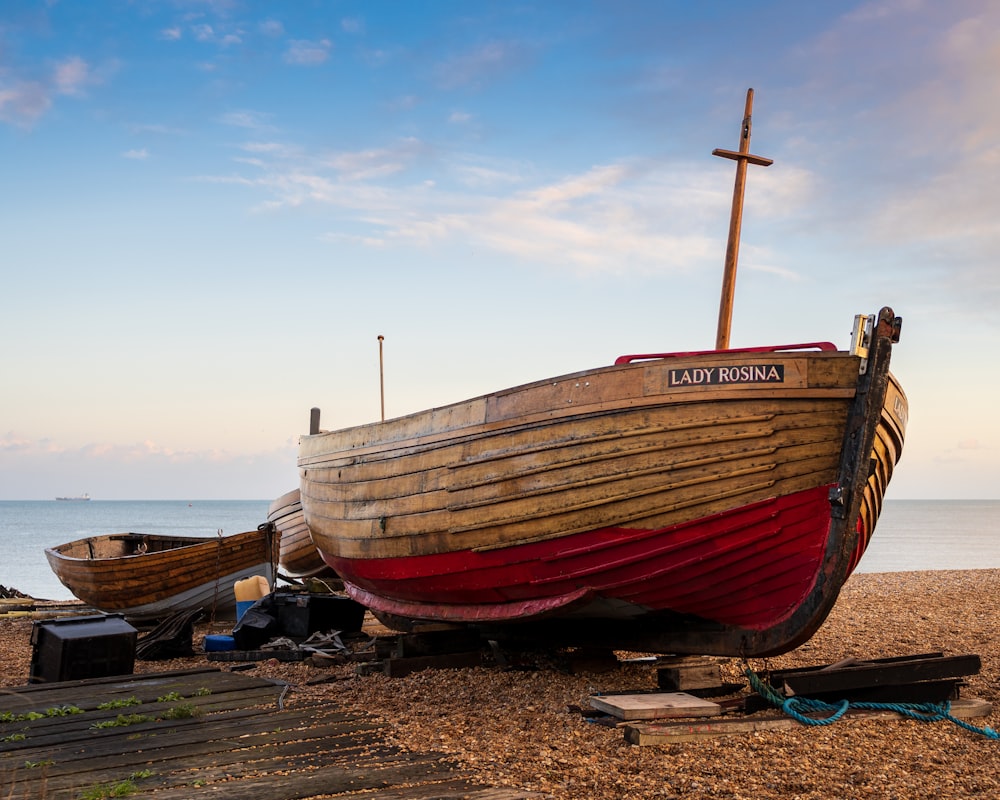 a boat sitting on top of a beach next to the ocean