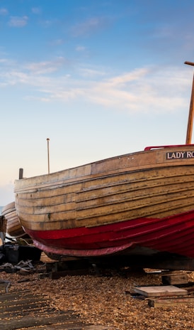 a boat sitting on top of a beach next to the ocean