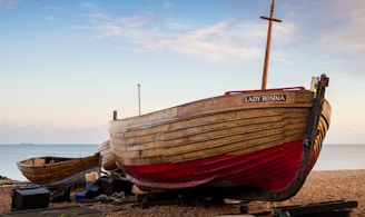 a boat sitting on top of a beach next to the ocean