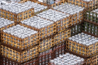 Stacks of neatly arranged beer cartons on pallets inside a clean warehouse.