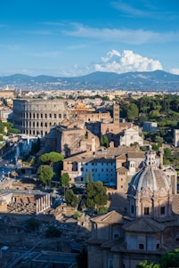 an aerial view of a city with buildings and mountains in the background