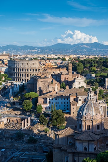 an aerial view of a city with buildings and mountains in the background