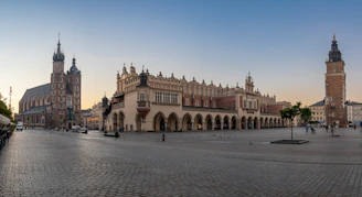 a city square with a clock tower in the background