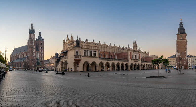 a city square with a clock tower in the background
