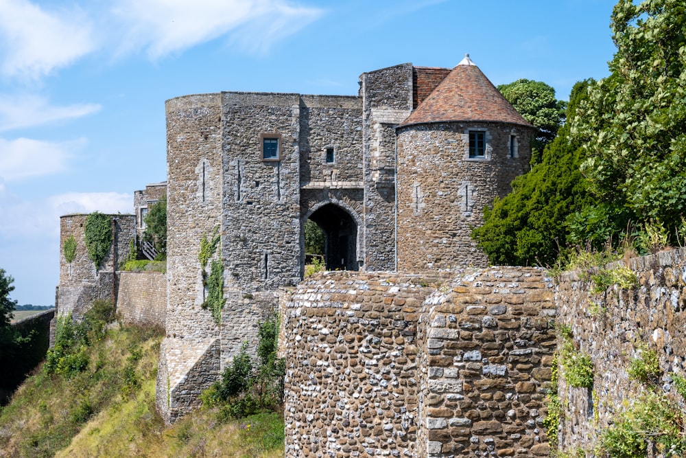 a stone castle on a hill with trees around it