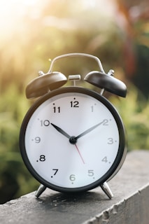 a black and white alarm clock sitting on a ledge