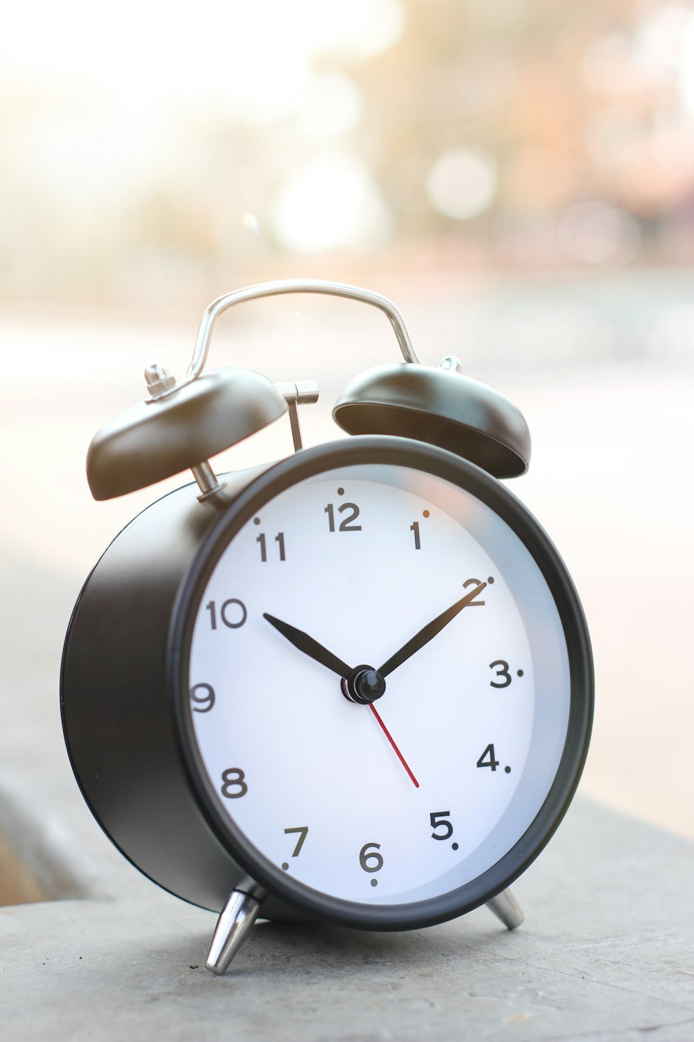 a black and white alarm clock sitting on a ledge