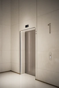 a white room with a silver door and a white wall