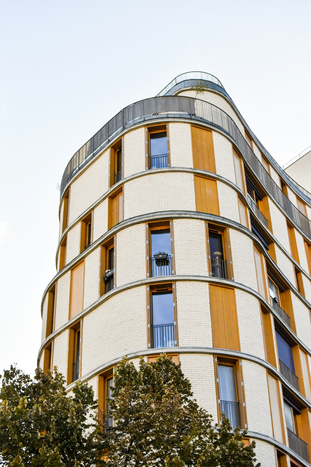 a tall building with many windows next to a tree