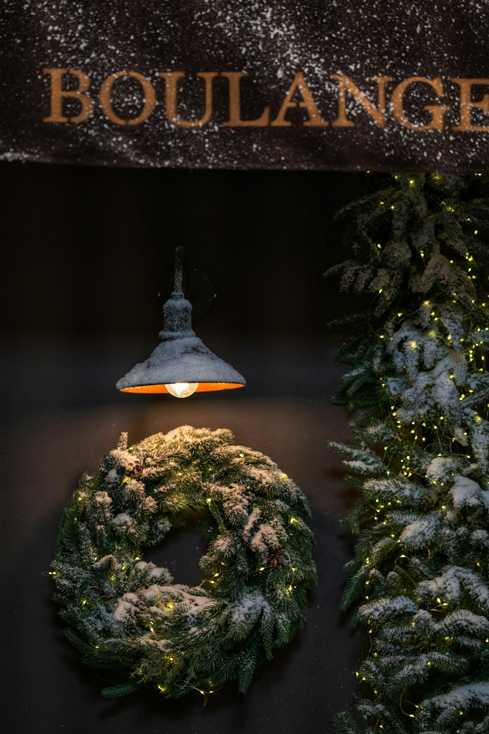 a christmas wreath and a light on a wall