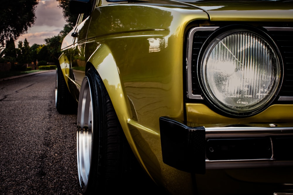 a close up of a yellow car on a street