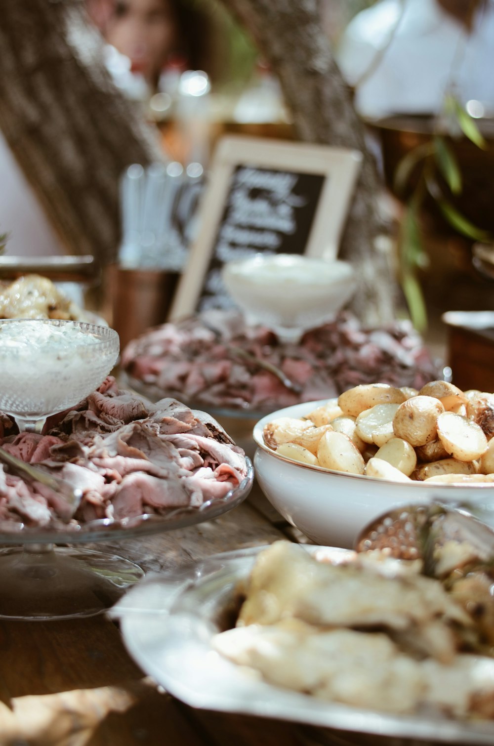 a table topped with plates of food covered in meat