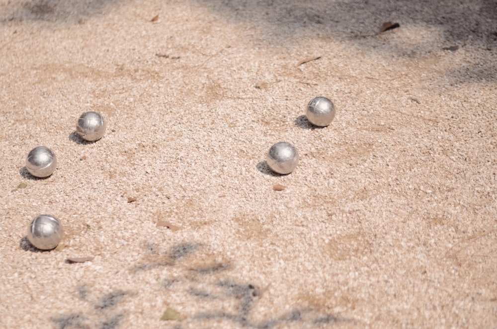a group of balls sitting on top of a sandy ground