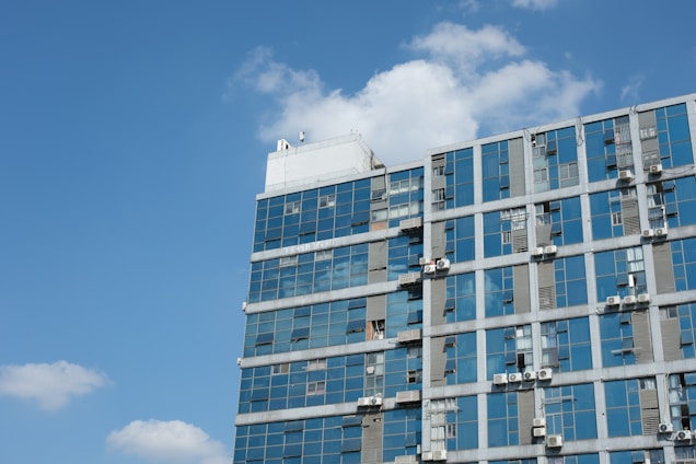 Technicians installing a sleek HVAC system inside a modern Dubai office building with red and blue accents.