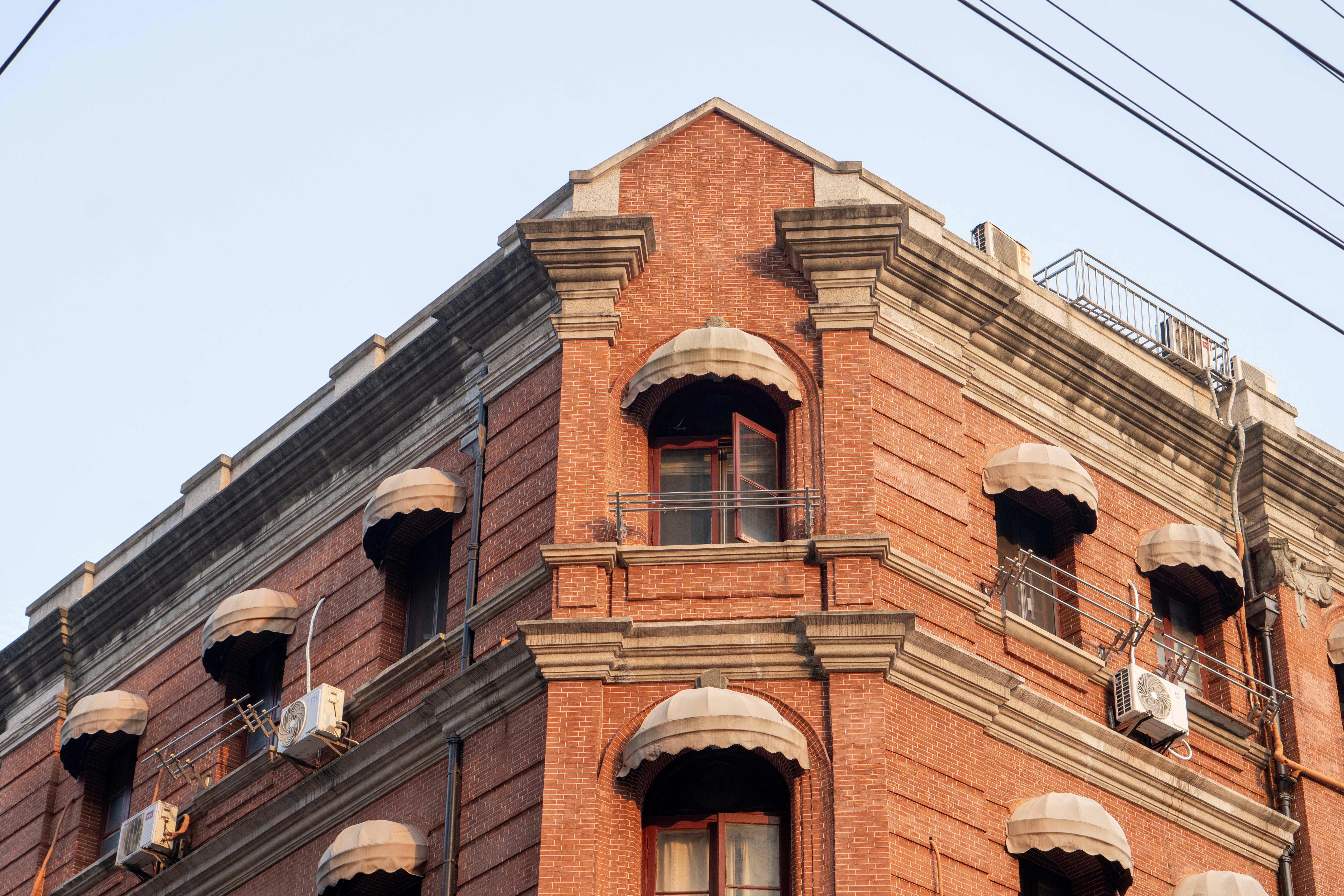 A red brick building with many windows and balconies photo – Free ...