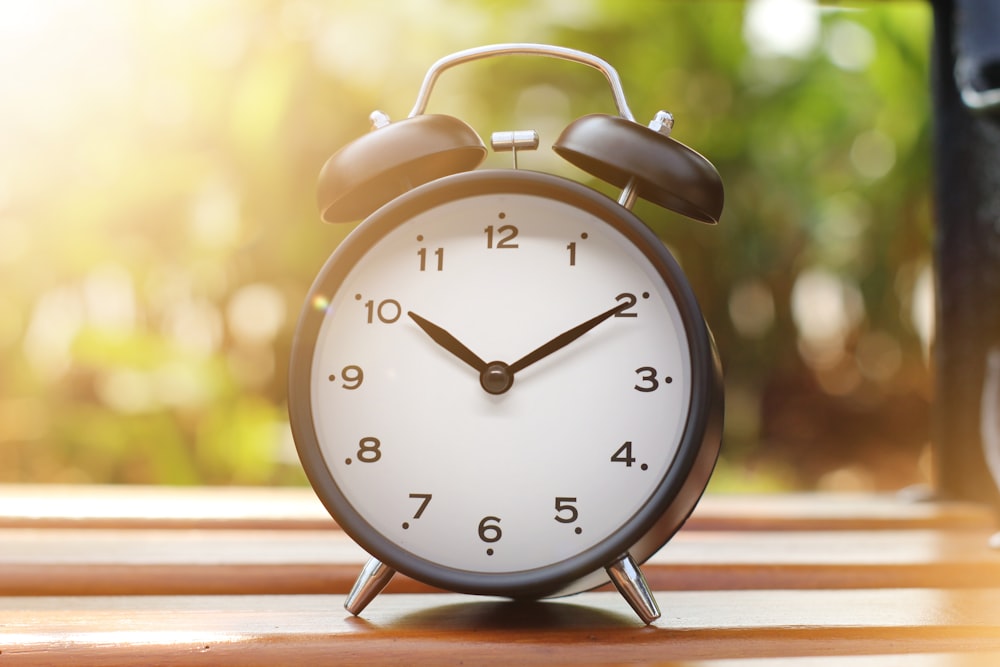 an alarm clock sitting on top of a wooden table