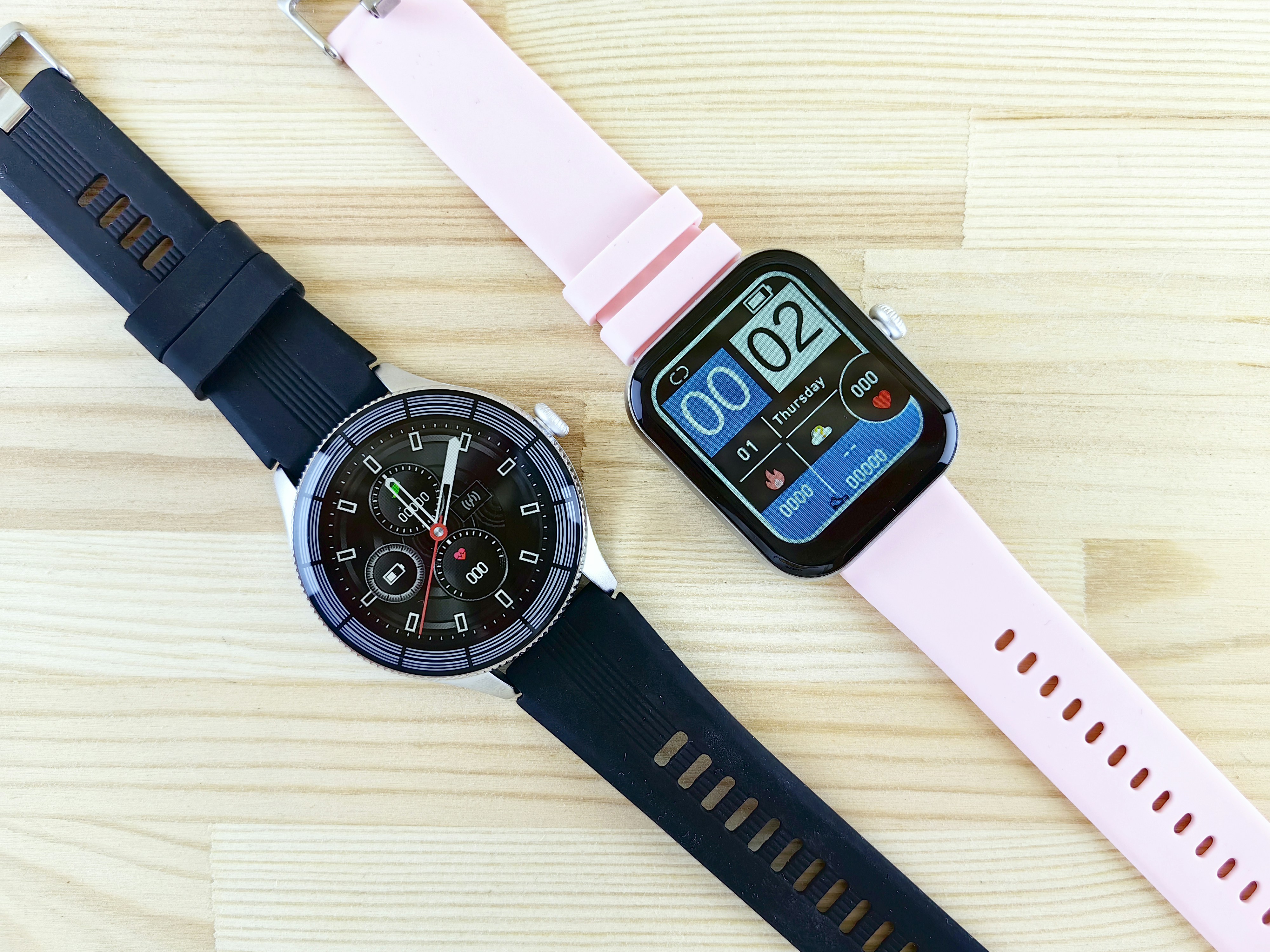 a smart watch sitting next to a smart watch on a wooden table