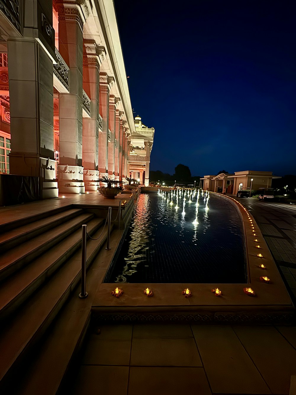 a long pool of water in front of a building