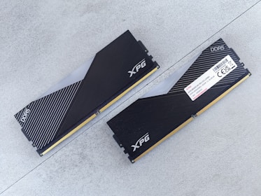 DDR4 and DDR5 RAM sticks arranged diagonally, highlighting their silver heat spreaders and modern design.