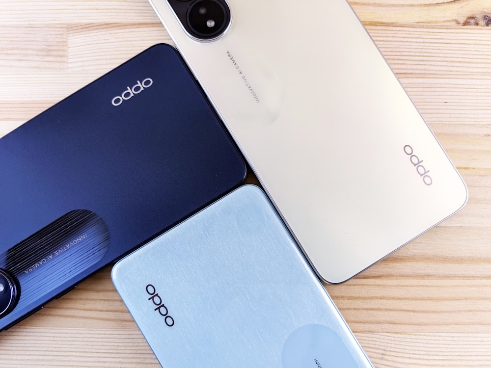 three oppo phones sitting on top of a wooden table