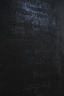 A close-up of ancient symbols and texts illuminated by candlelight.