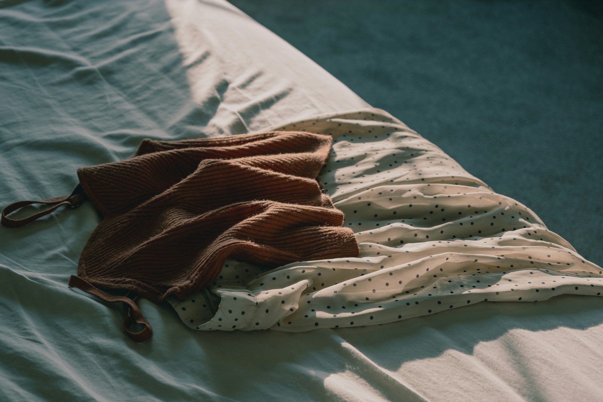 an unmade bed with a blanket on top of it