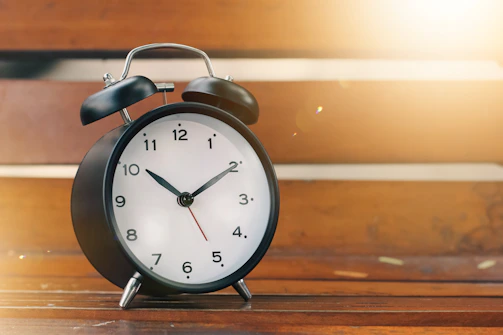 Vintage flip clock on a minimalist wooden desk bathed in warm afternoon light