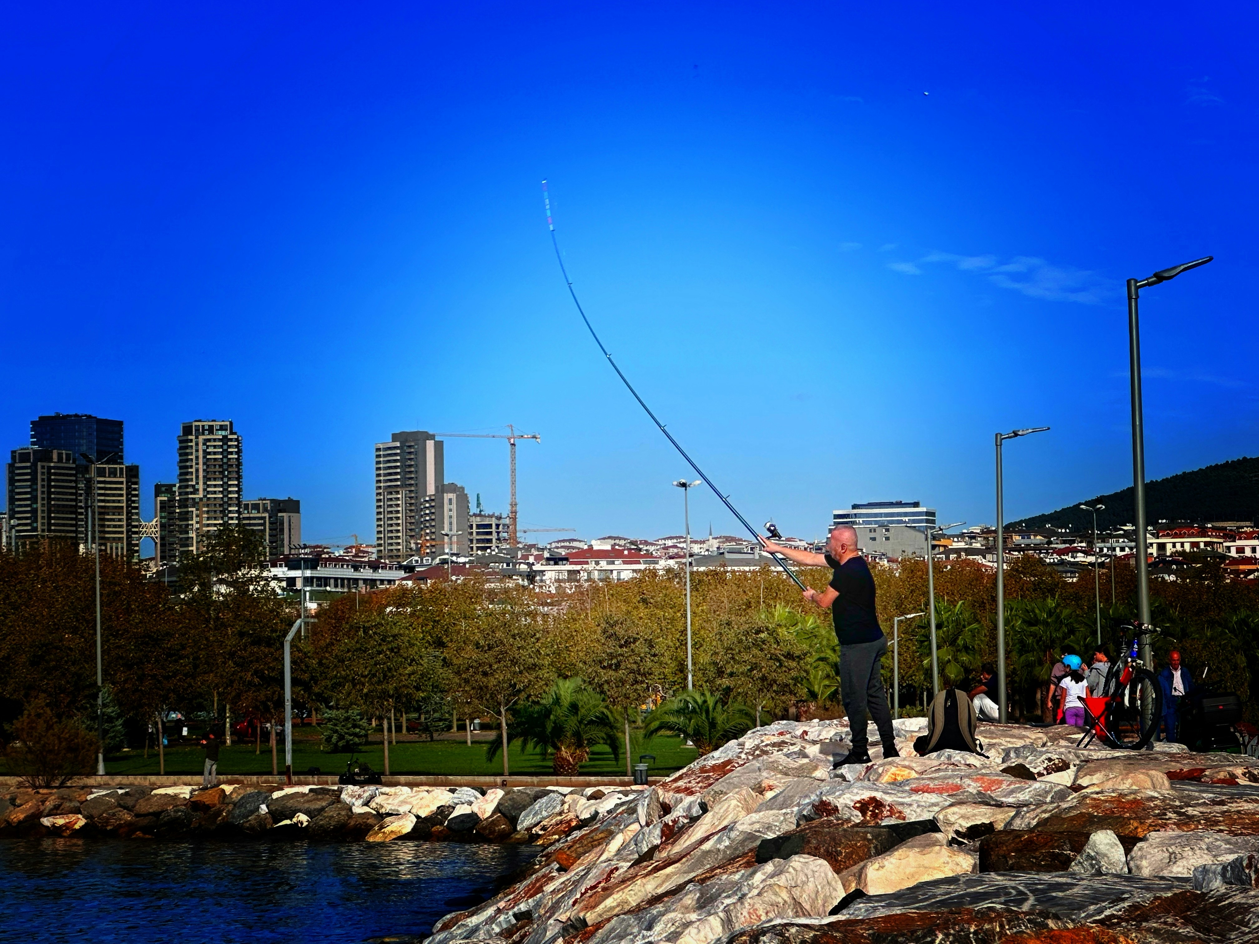 a man flying a kite in a city park