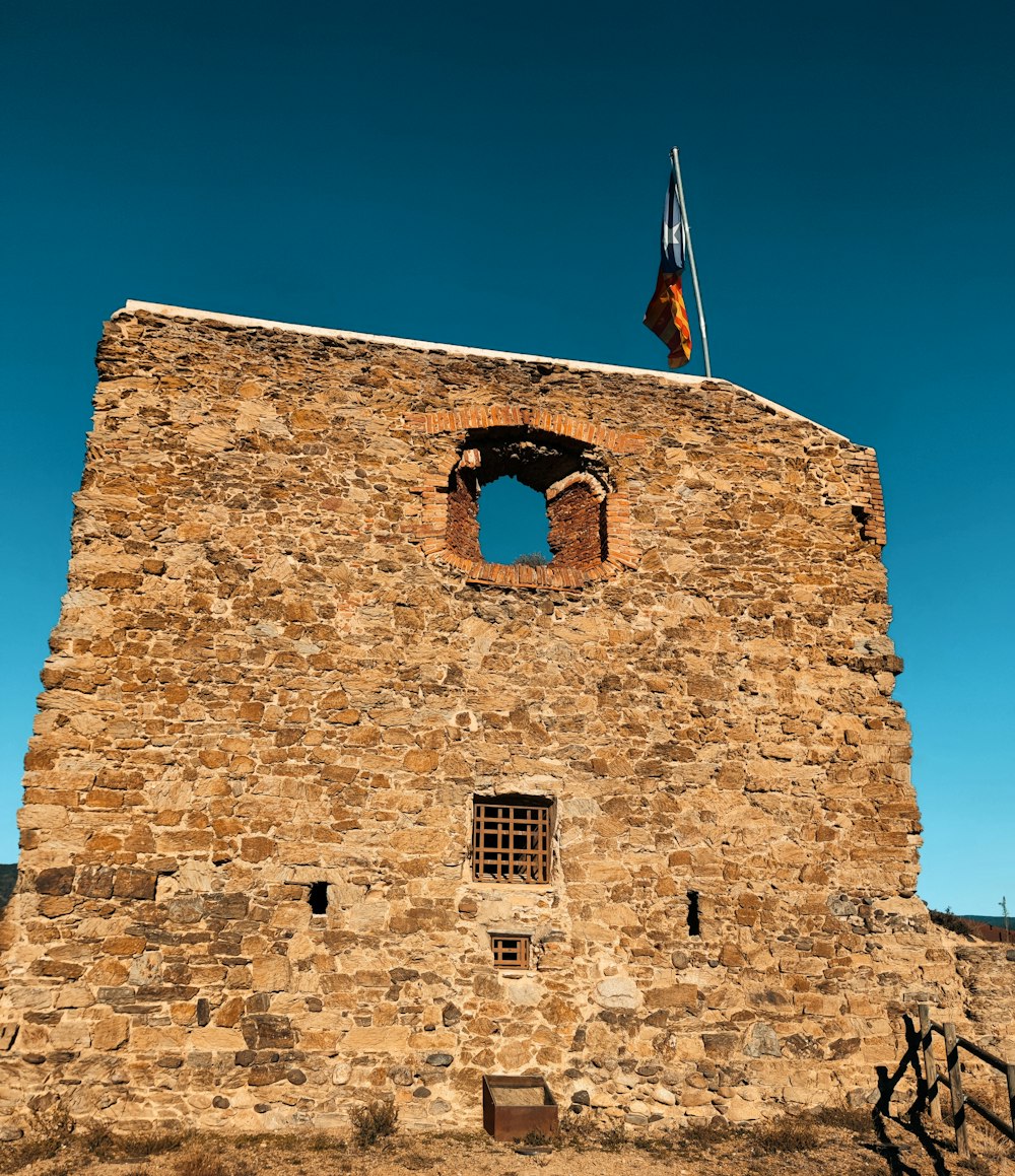 a stone building with a flag on top of it