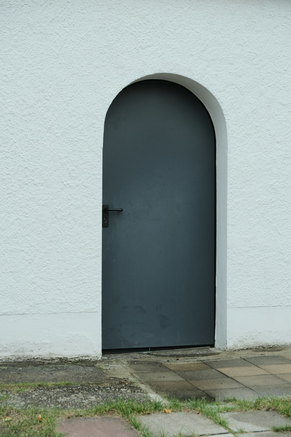 a white building with a black door on the side of it