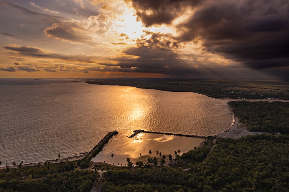 an aerial view of a lake and a dock at sunset