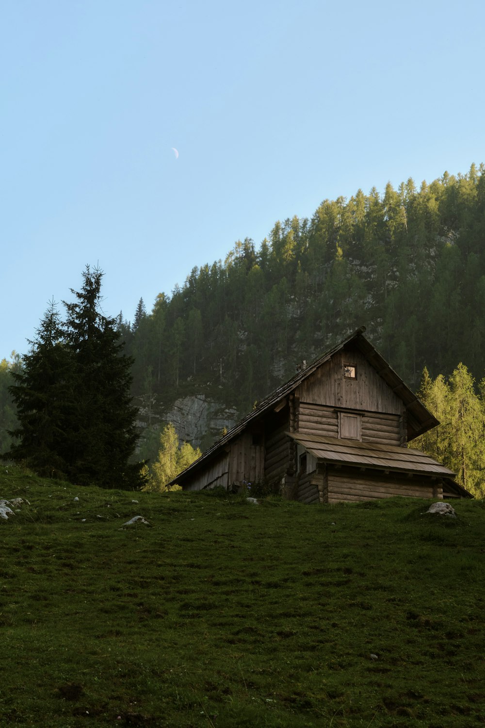 a small cabin in the middle of a grassy field