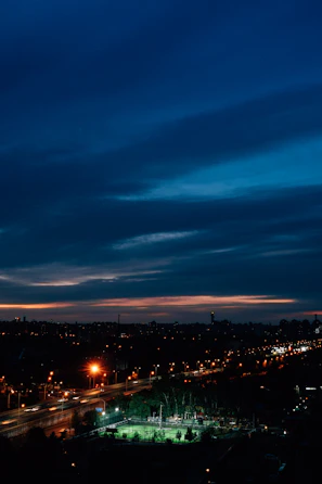 A wide shot of the Newcastle skyline at dusk, with players silhouetted in the foreground on an outdoor futsal court.