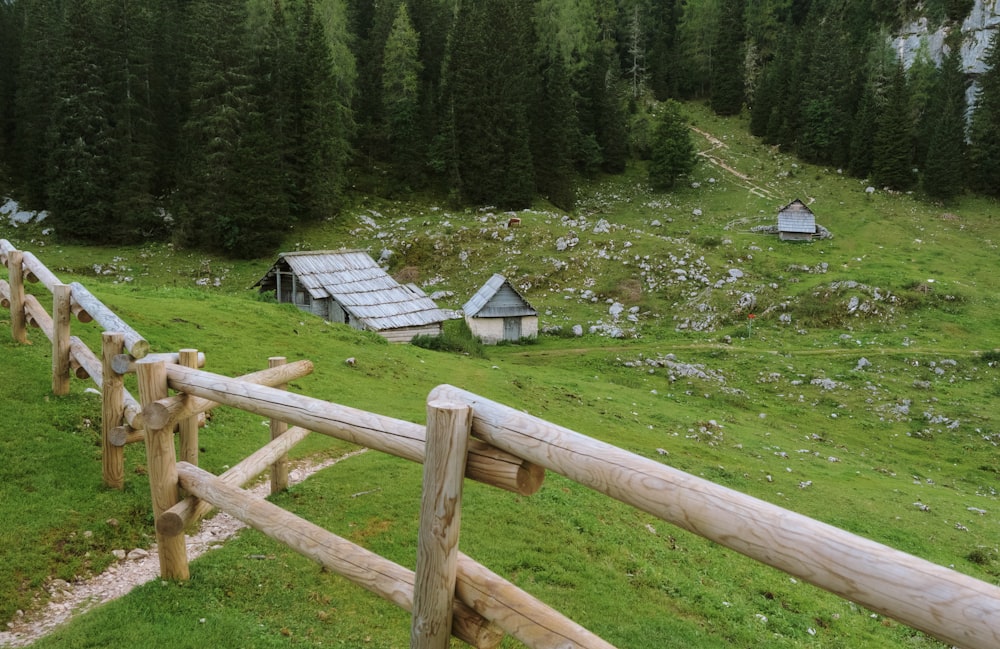 a wooden fence in front of a grassy field