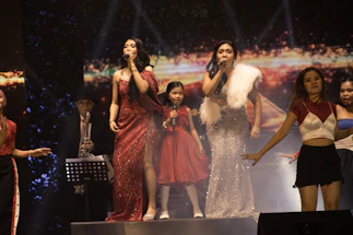 A vibrant photo of the female saxophone quartet performing under colorful stage lights.