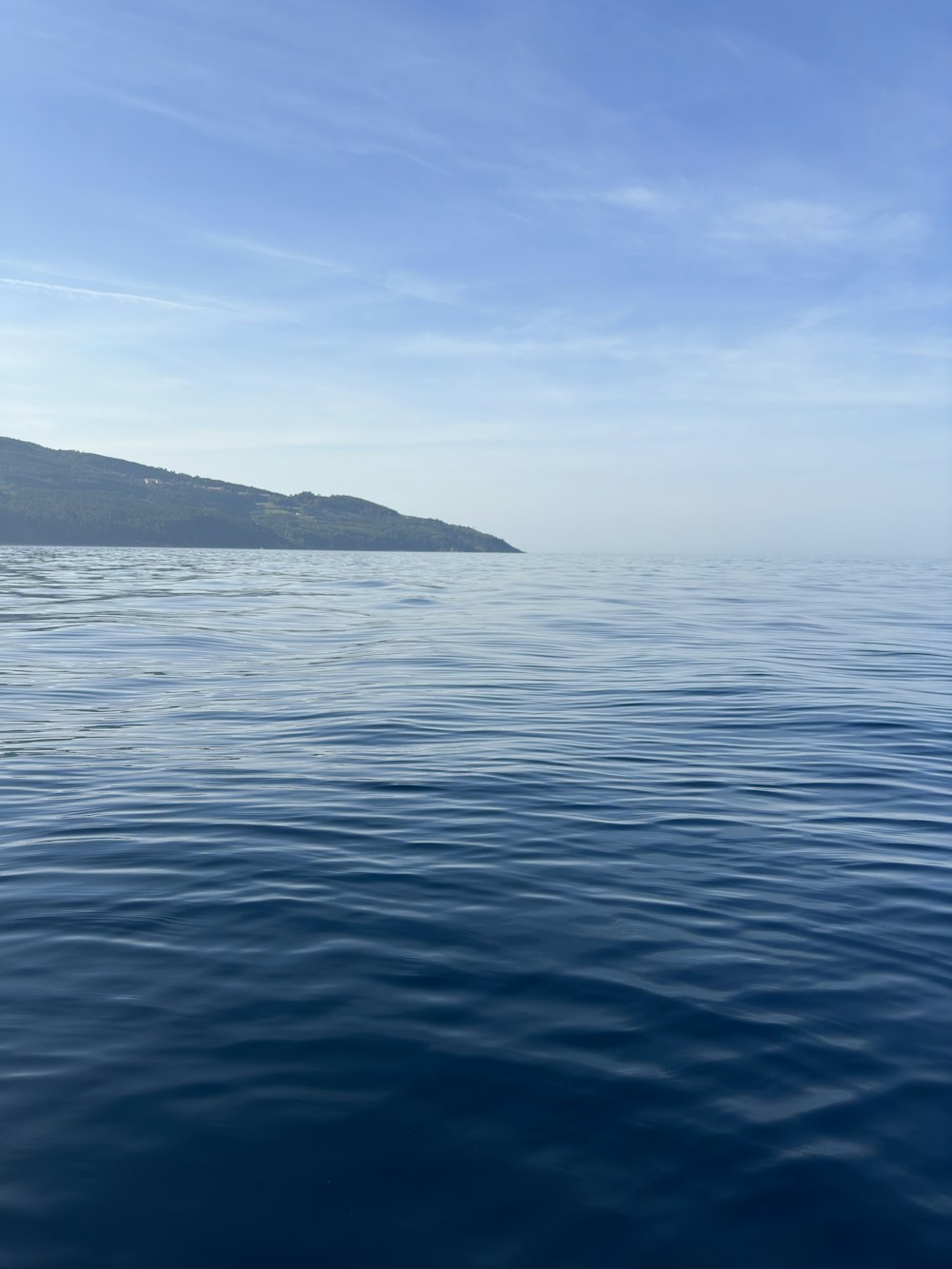 a body of water with a hill in the distance