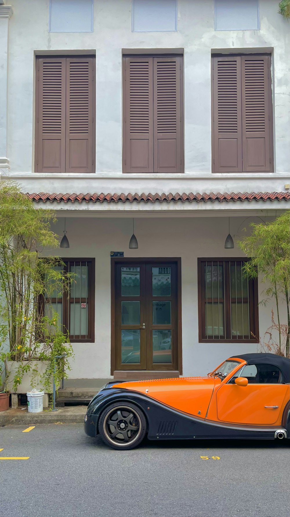 an orange and black car parked in front of a building