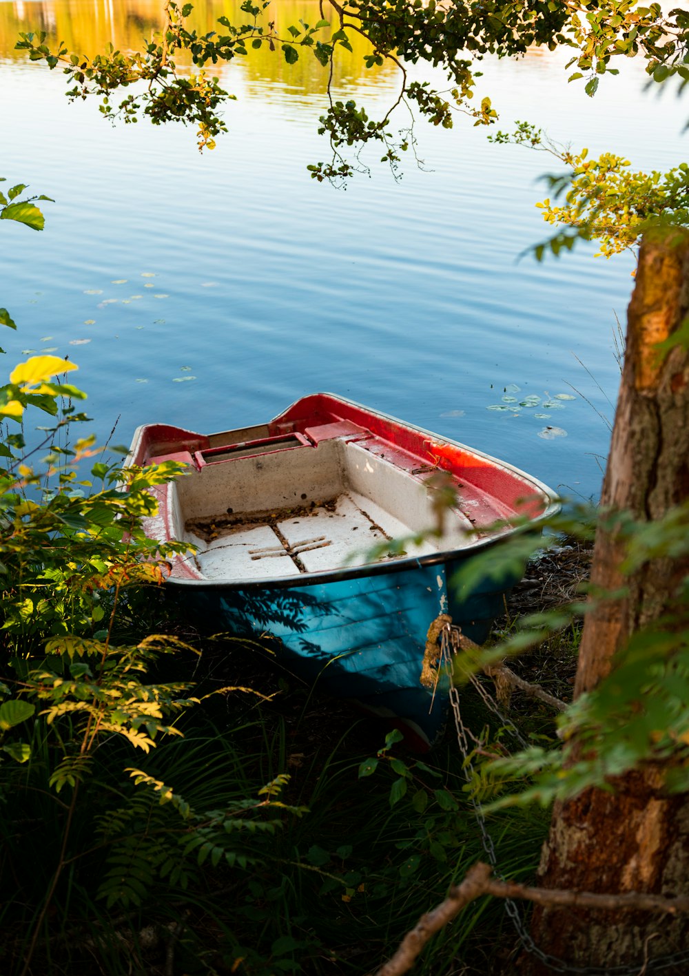 a red and white boat sitting on top of a body of water