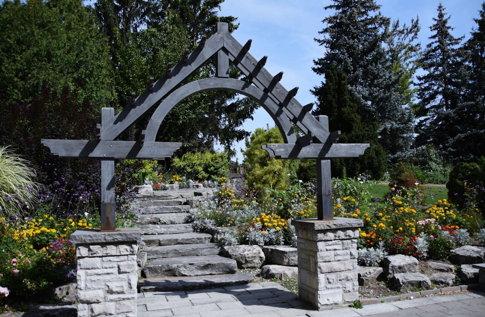 a garden with stone steps and a wooden trellis