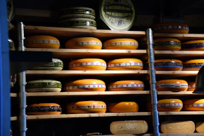Artisan cheese wheels aging in a cozy cellar with warm lighting