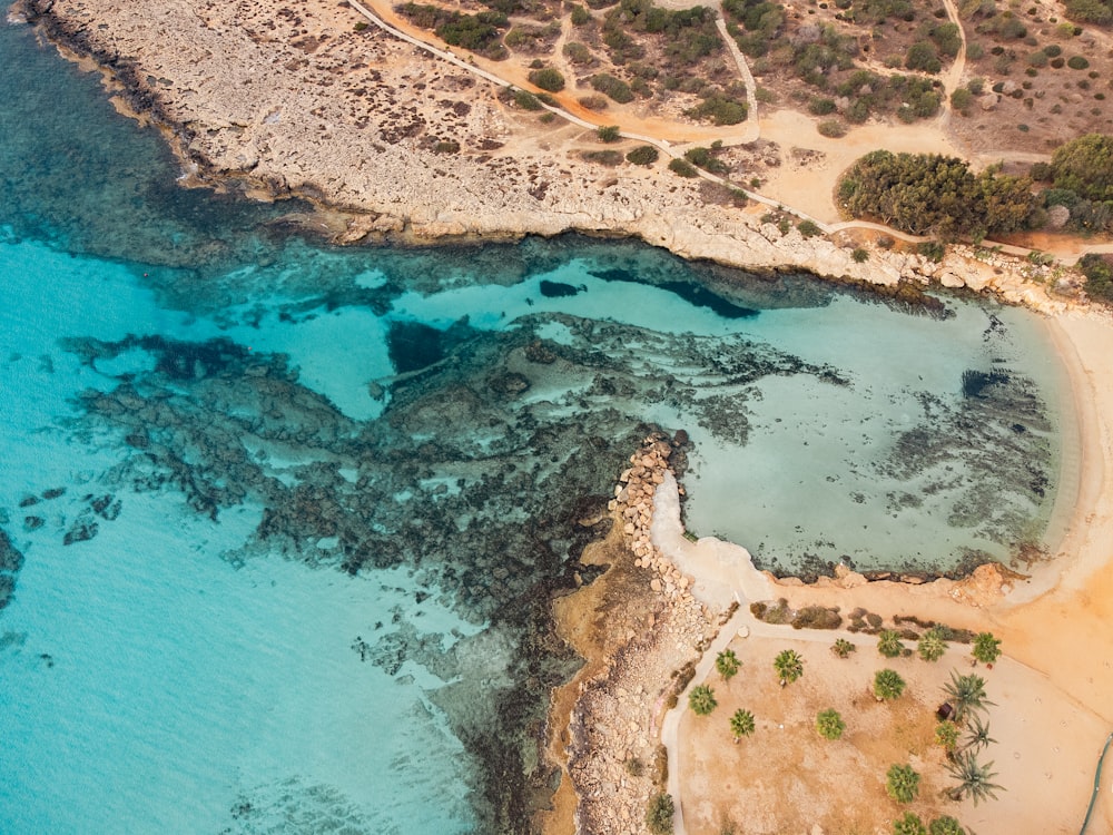 an aerial view of a beach with blue water