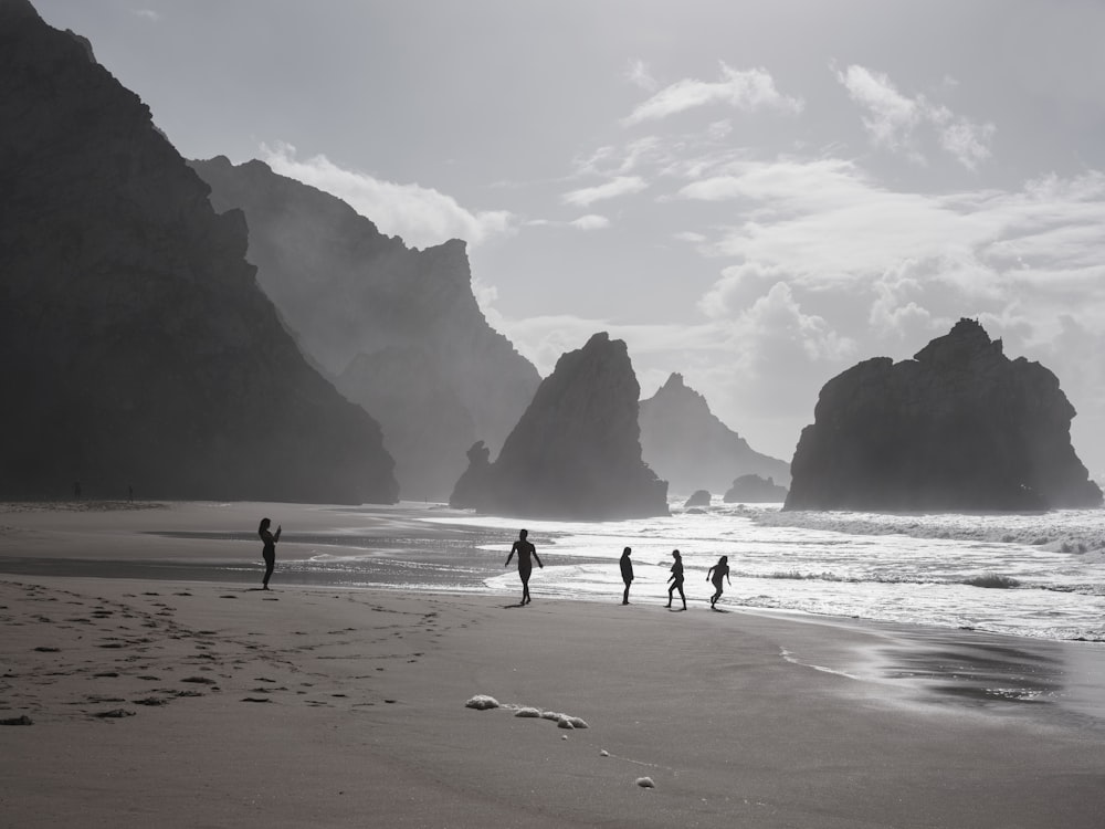 a group of people standing on top of a sandy beach