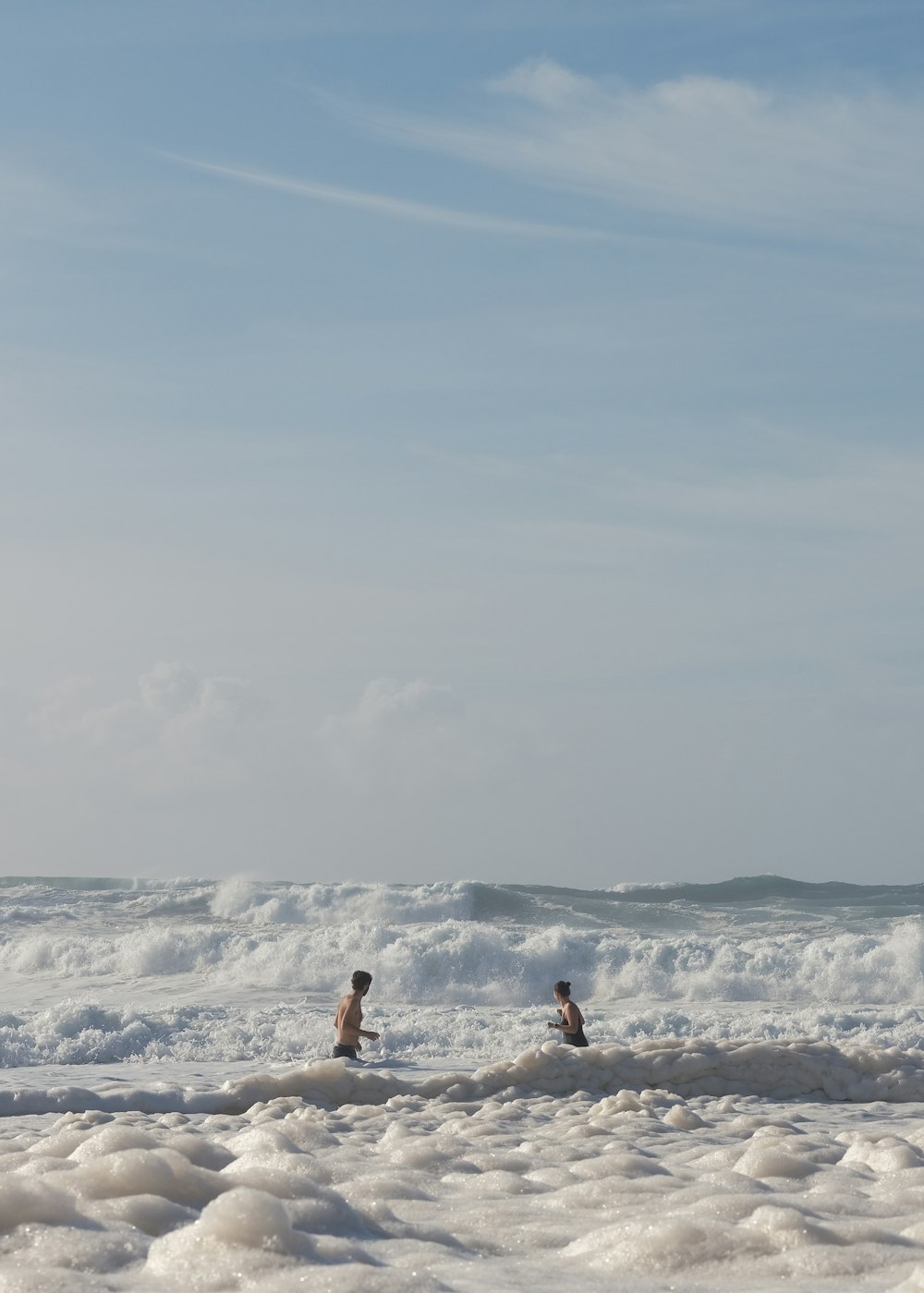 a couple of people riding surfboards on top of a wave