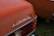 The rear end of a vintage car is featured with a close-up of the 'Automatic' emblem prominently displayed. The car is painted in a burnt orange color and the taillight assembly includes clear and red lenses. The setting appears to be an outdoor area with green grass visible.